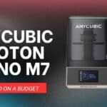 A highly detailed, painted miniature figure printed on the Anycubic Photon Mono M7 3D printer, shown next to the printer itself to demonstrate its incredible 14K resolution.